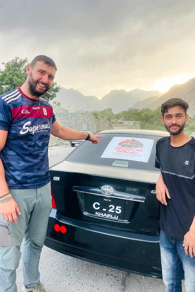 a happy American tourist in Skardu Pakistan endorsing the car rental services of Skardu on Wheels