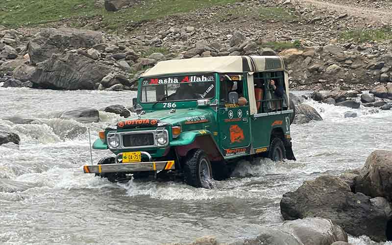 jeep crossing a fast flowing stream of water